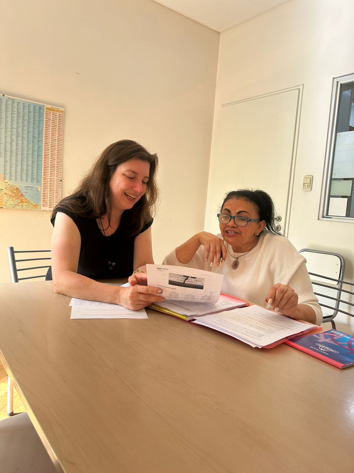 A Verbum teacher guiding a student through Spanish exercises at a classroom table
